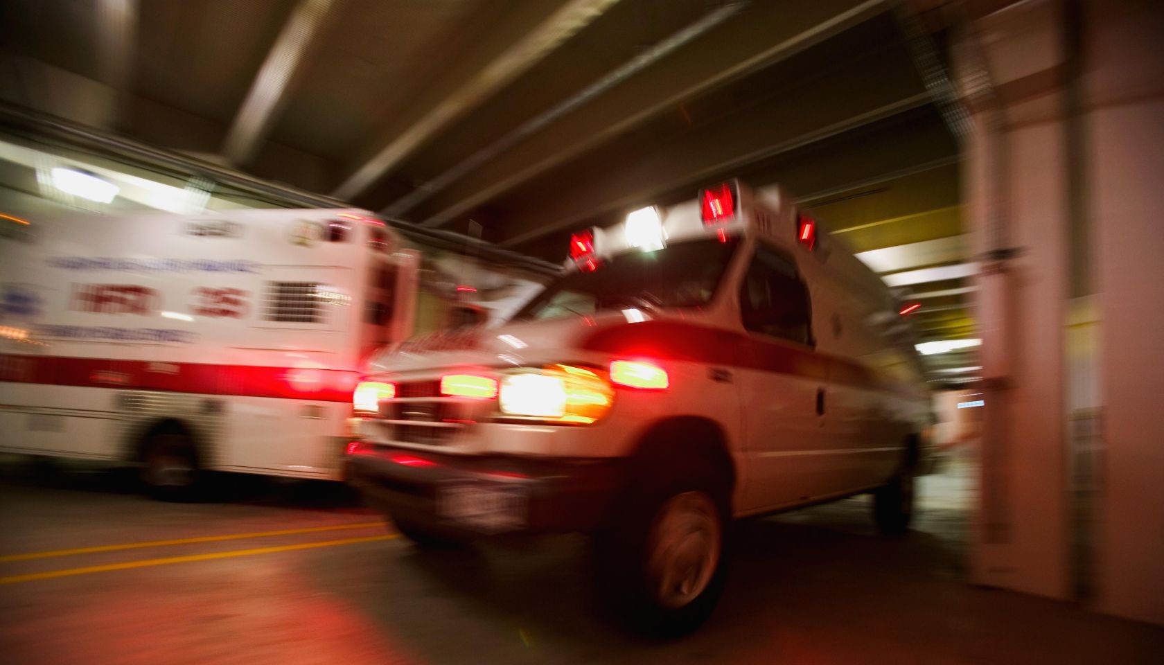 Ambulance pulling away from hospital (blurred motion)