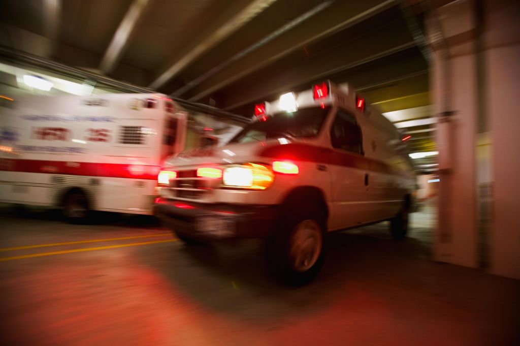 Ambulance pulling away from hospital (blurred motion)