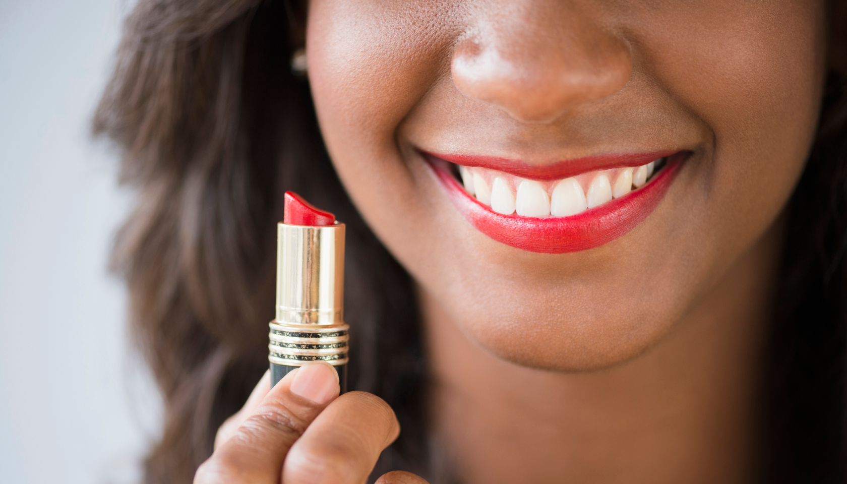 Black woman holding lipstick