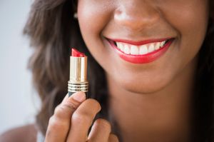Black woman holding lipstick