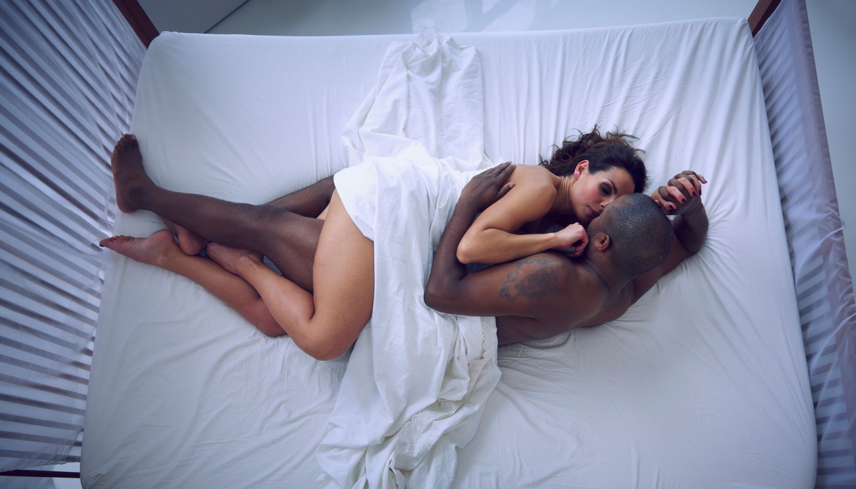 Woman and man cuddling in bed