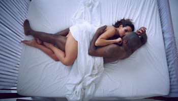 Woman and man cuddling in bed