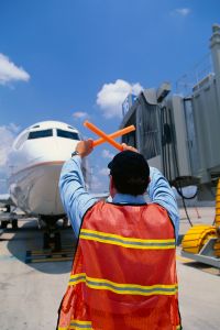 Ground crew directing plane to the gate jetway