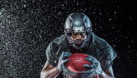 Water splashing on black football player
