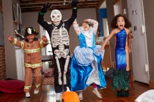 Children in Halloween costumes jumping for joy