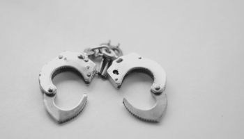 High Angle View Of Handcuffs Over White Background