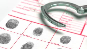 Looking At Finger And Thumb Prints at Police Station, with Handcuffs