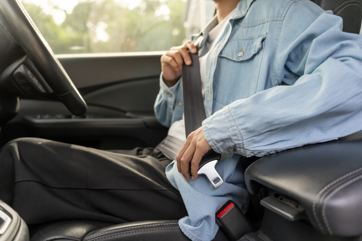 Woman use seatbelt and drives with intent, safe driving, driving practice, cheerful woman sits comfortably in the driver's seat with her hand confidently , readiness for a journey