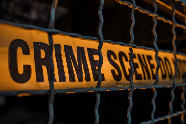 Crime Scene Tape Behind Metal Fence at Night